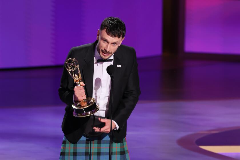 Man in kilt holding an Emmy