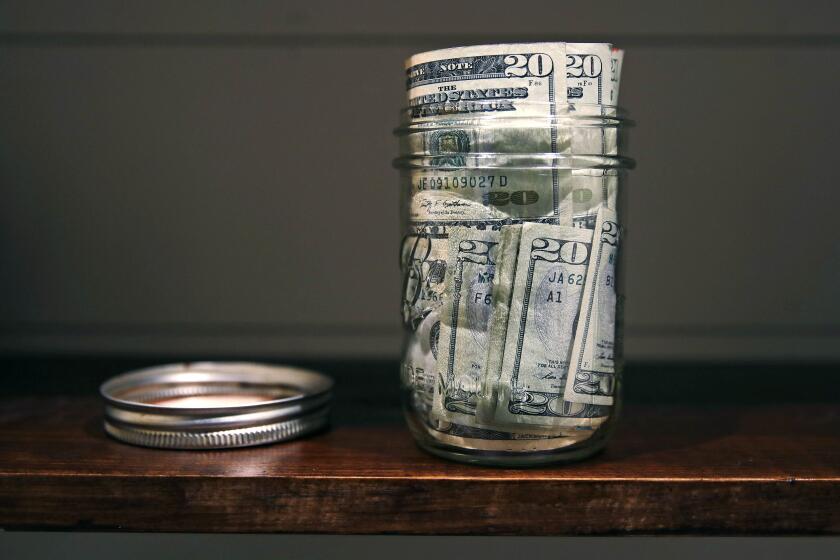 In this June 15, 2018, photo a canning jar filled with currency sits on a shelf in East Derry, N.H. (AP Photo/Charles Krupa)