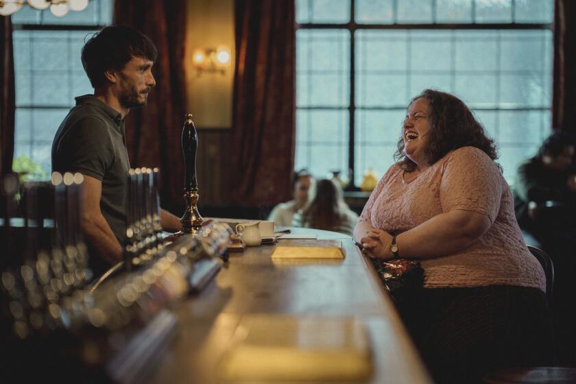 A bartender (Richard Gadd) stares across the bar at a woman sitting and laughing (Jessica Gunning).