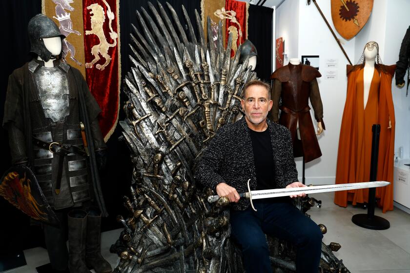 Heritage Auctions Vice President Joe Maddalena sits on the Iron Throne during the "Game of Thrones" auction