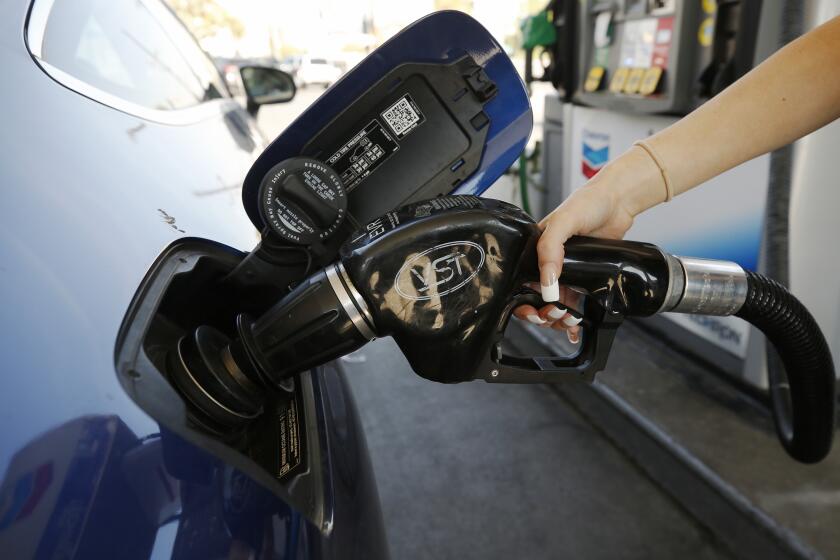 LOS ANGELES, CA - NOVEMBER 15: Montana Tomkyns, 23, puts fuel in her gas tank as drivers select from various fuels all priced over $6 dollars at a Chevron Gas Station located at North Alameda and West Cesar Chavez Ave near Union Station in downtown Los Angeles as California gas prices hit an average price of $4.676 Sunday, setting the highest recorded average price for regular gasoline, according to AAA. America's largest state by population has the highest gas prices in the country. The national average dropped slightly to $3.413 Sunday. Downtown on Monday, Nov. 15, 2021 in Los Angeles, CA. (Al Seib / Los Angeles Times).