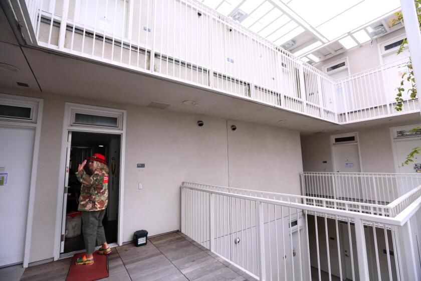 VENICE, CA - JUNE 7, 2024 - Aauti Sumaiyya, in her 70s, says goodbye to a visitor before entering her apartment at the Rose Apartments in Venice on June 7, 2024. Sumaiyya, who lived homeless in Venice for many years, was living at "A Bridge Home," housing in Venice before being offered housing at the Rose Apartments. The Rose Apartments, operated by Venice Community Housing, offers affordable housing for the homeless. (Genaro Molina/Los Angeles Times)