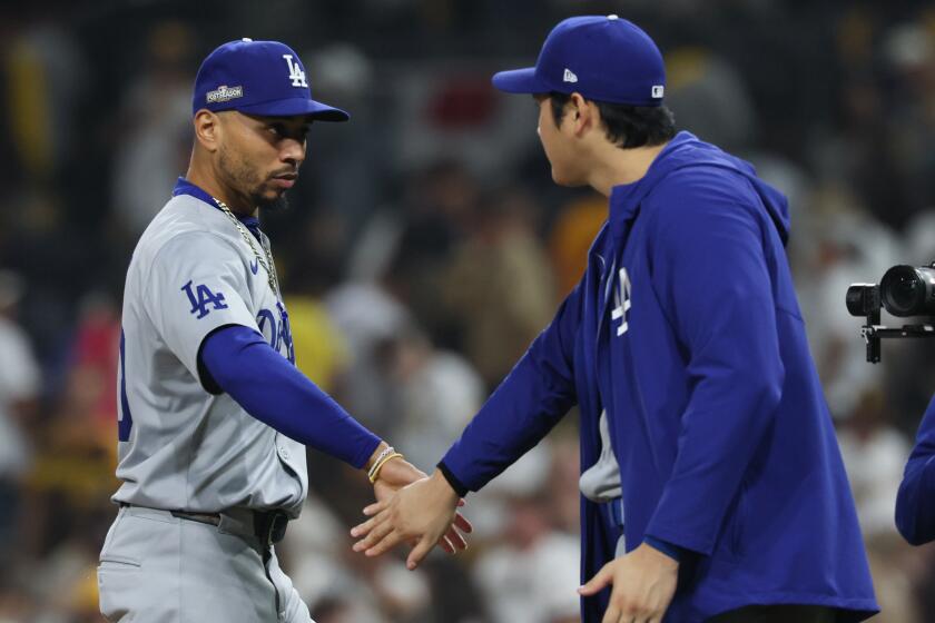 SAN DIEGO, CALIFORNIA - OCTOBER 09: Mookie Betts #50 of the Los Angeles Dodgers slaps hands with Shohei Ohtani #17 after defeating the San Diego Padres 8-0 in game four of the National League Division Series at Petco Park on Wednesday, Oct. 9, 2024 in San Diego. (Robert Gauthier / Los Angeles Times)