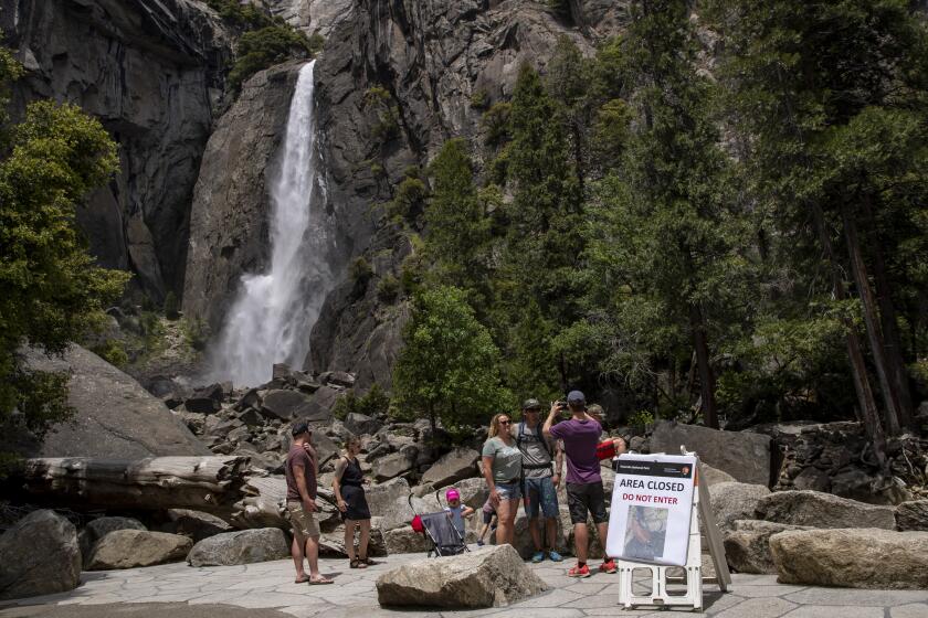 Visitors to Yosemite Valley take photographs at Lower Yosemite Falls