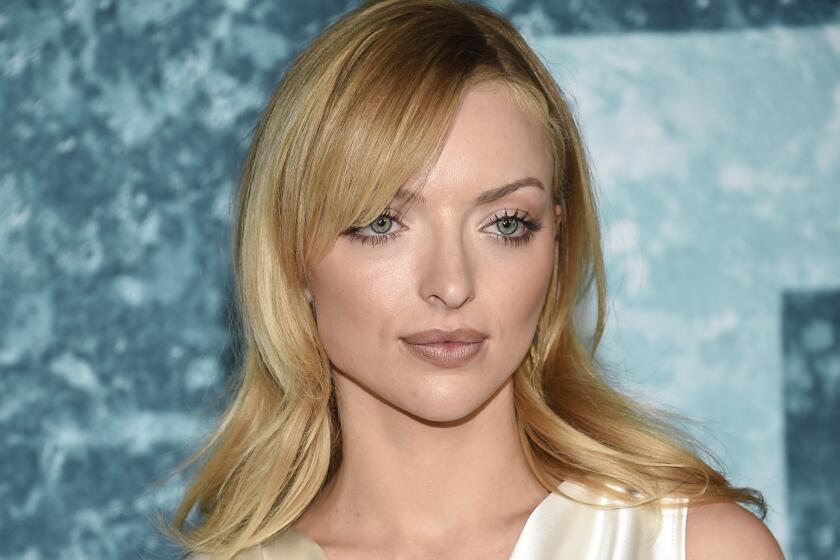 Francesca Eastwood poses in a white silky gown at a film premiere