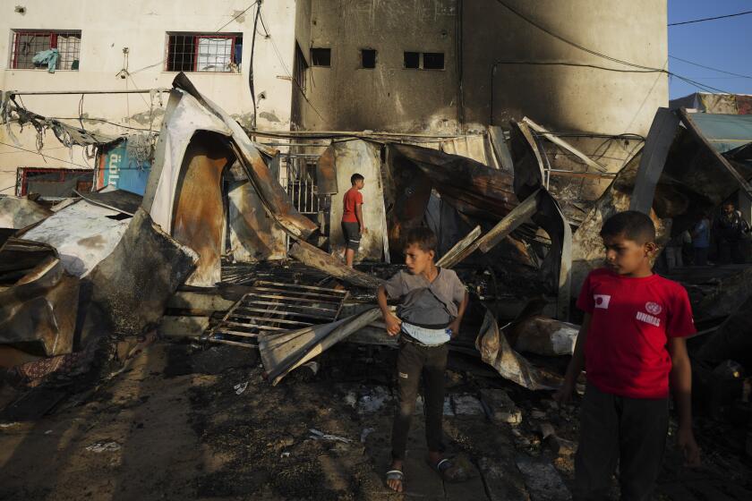 Palestinians look at the damage after an Israeli strike hit a tent area in the courtyard of Al Aqsa Martyrs hospital in Deir al Balah, Gaza Strip, Monday, Oct. 14, 2024. (AP Photo/Abdel Kareem Hana)