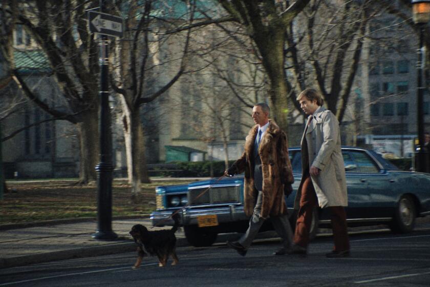 Two men walk a dog in New York City.