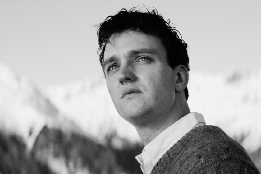 A man looks inquisitively at a mountain chalet.