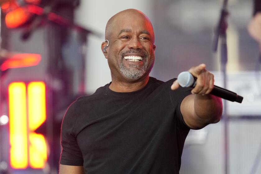 Darius Rucker smiles and points with a mic in hand while performing in a black t-shirt on NBC's "Today" show in 2023