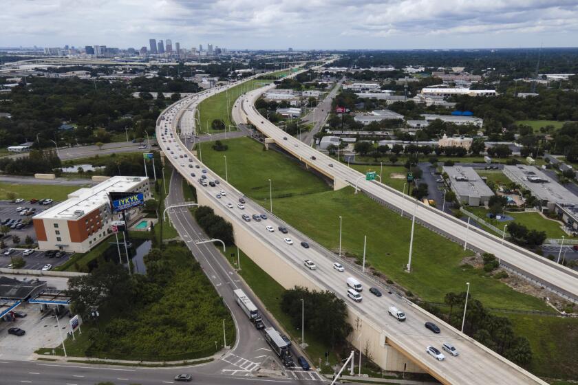 In this image taken with a drone, the Tampa, Fla., skyline, top left, is seen at a distance as traffic flows eastbound, left lanes, along Interstate 4 as residents continue to follow evacuation orders ahead of Hurricane Milton, Tuesday, Oct. 8, 2024. (AP Photo/Julio Cortez)