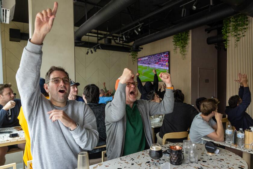 Culver City, CA - September 29: Edwin Cox, left, and friend Alex Black, right, celebrate as Tottenham scores a goal against Manchester United while watching European Premier League match at N17 The Lane on Sunday, Sept. 29, 2024 in Culver City, CA. (Brian van der Brug / Los Angeles Times)