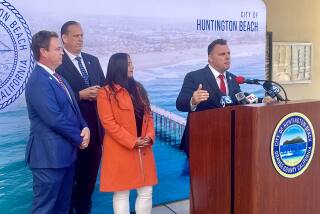 Huntington Beach City Atty. Michael Gates, flanked by City Council members Casey McKeon, Tony Strickland and Gracey Van Der Mark, addresses the media at a press conference at City Hall on Monday.