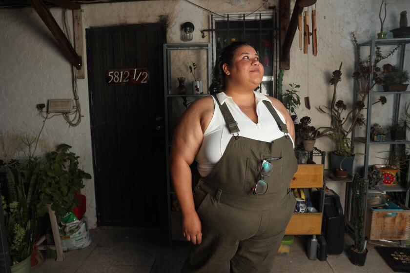 Los Angeles, CA - August 23: Mariana Puche Hernandez poses for a portrait in front of her apartment on Friday, Aug. 23, 2024 in Los Angeles, CA. Hernandez has benefited from a community land trust called Fideicomiso Comunitario Tierra Libre, that renovated and restricted the rents of her apartment. (Michael Blackshire / Los Angeles Times)