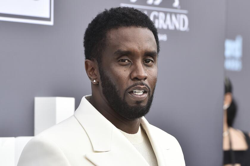 Sean "Diddy" Combs in a white shirt and suit jacket posing against a gray background with white text