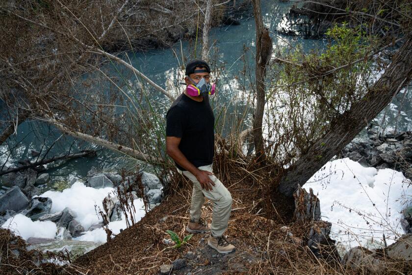 Ramon Chairez, stands a top the bridge above the Tijuana River at Saturn Boulevard.