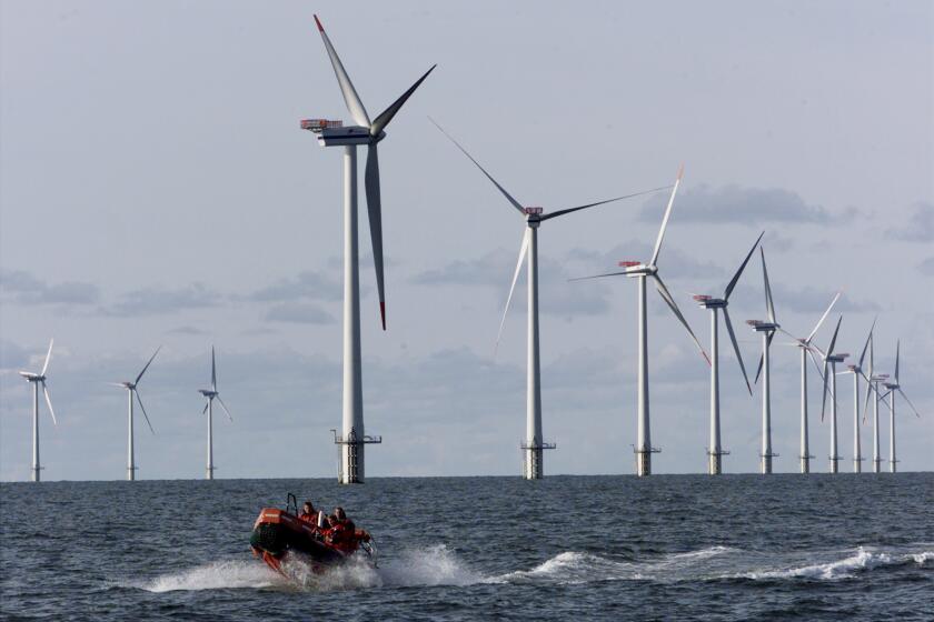 ** FILE** A speed boat passes by offshore windmills in the North Sea offshore from the village of Blavandshuk near Esbjerg, Denmark, in this file photo taken on Wednesday, Oct.30, 2002. A plan to build the first offshore wind farm in the United States cleared a key hurdle Friday, March 30, 2007, winning Massachusetts state approval of an environmental report submitted by the project's developers. Cape Wind Associates hope to build 130 windmills over 25 miles of federal waters in Nantucket Sound. The turbines would up to 440 feet above sea level when the tallest blade is pointing straight up. (AP Photo/Heribert Proepper)